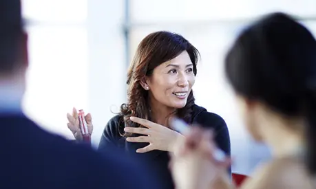 A woman gesticulating in a meeting.