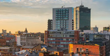 A view of the Manchester City centre skyline at sunset