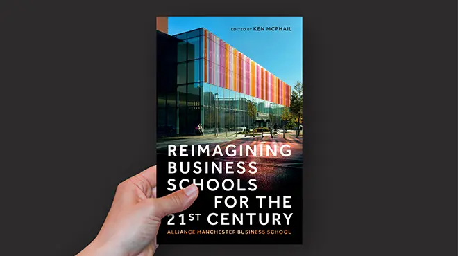 Hand holding the Reimagining Business Schools for the 21st Century book