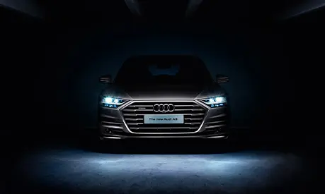 A picture of an Audi car with a licence plate that says 'The new Audi A8' with a black background
