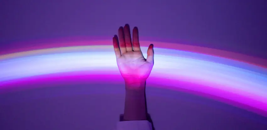 A hand displayed with a rainbow to denote equality.