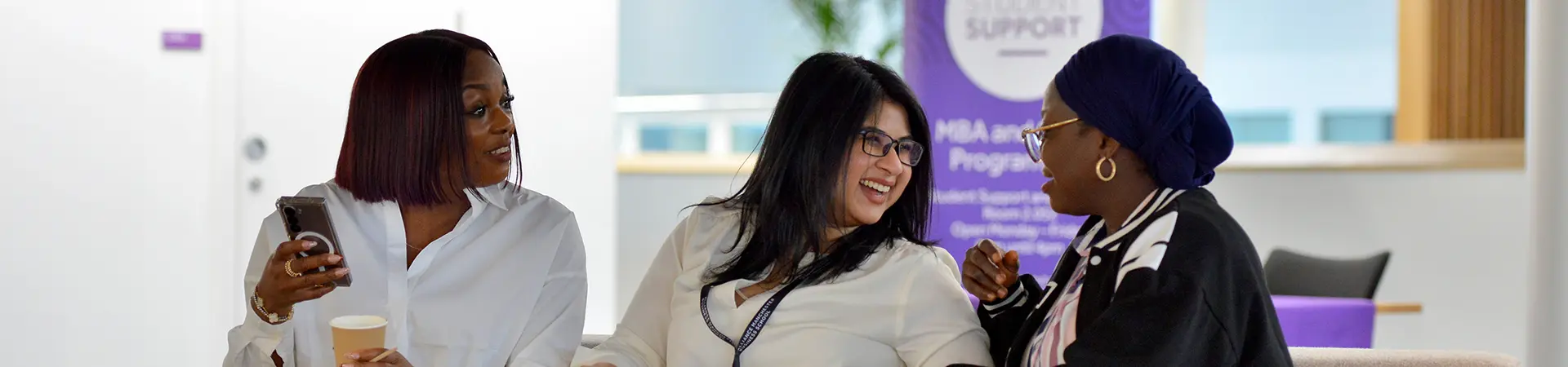 A group of women sitting and smiling together.