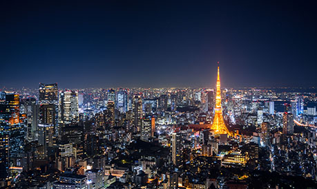 The Tokyo skyline, lit up at night and seen from above.
