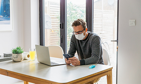 A man working from home with a face mask on