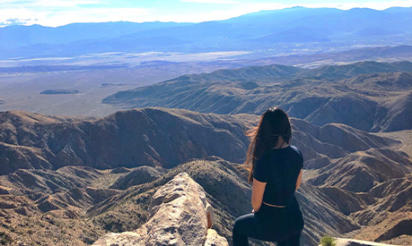 A student sitting down overlooking the grand canyon