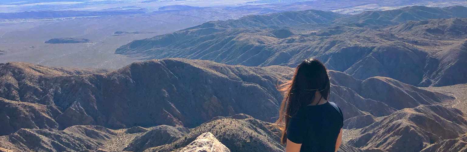 A student sitting down overlooking the grand canyon