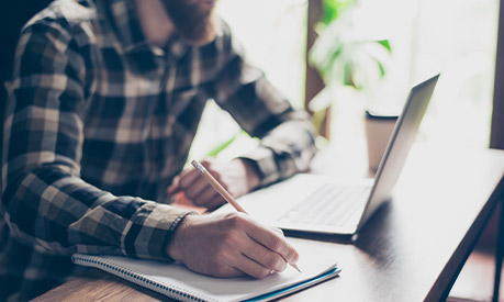 Man writing on notepad 