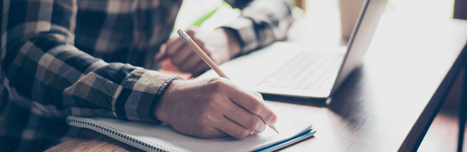 Man writing on notepad 