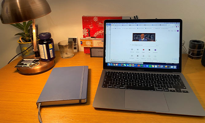 A desk with a laptop and pad on it 