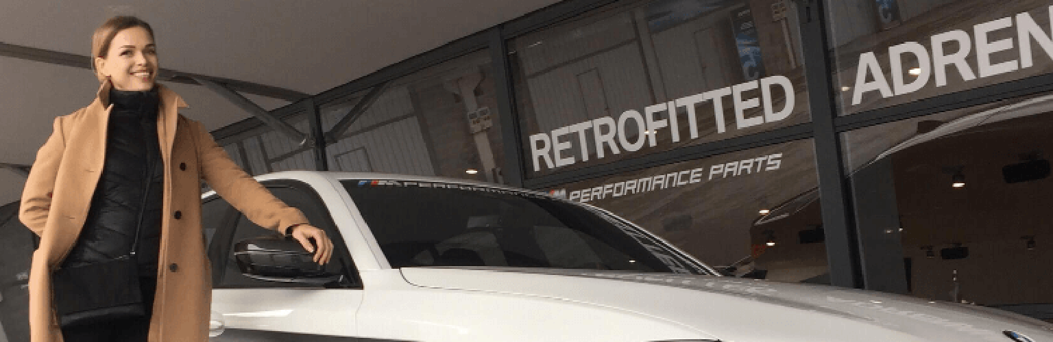 A woman standing next to a white sports car