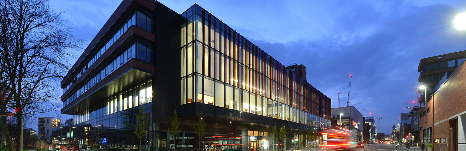 An image of the Alliance Manchester Business School building at night