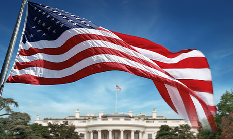 united states of america flag with the white house in the background