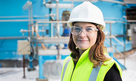 Elle Perschke from British Salt standing in the factory in a hi-vis jacket