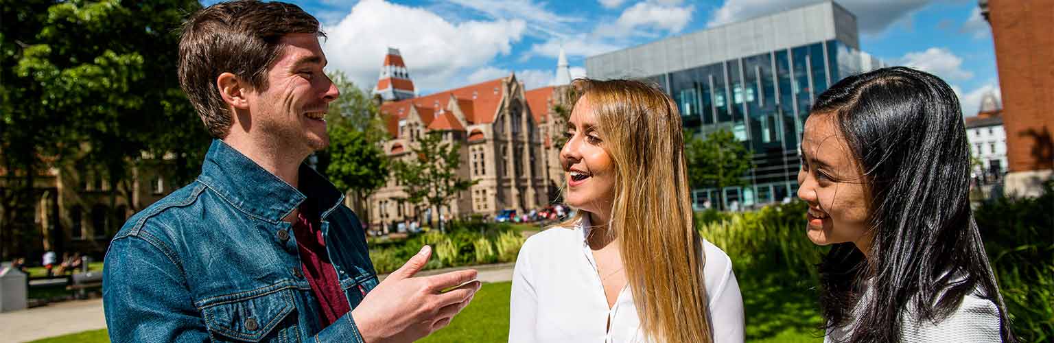 students at Manchester University campus smiling 