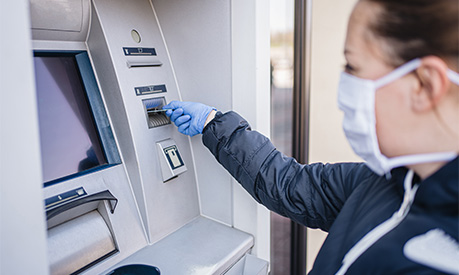 A woman entering her credit card in a cash machine