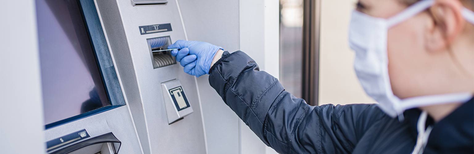 A woman entering her credit card in a cash machine