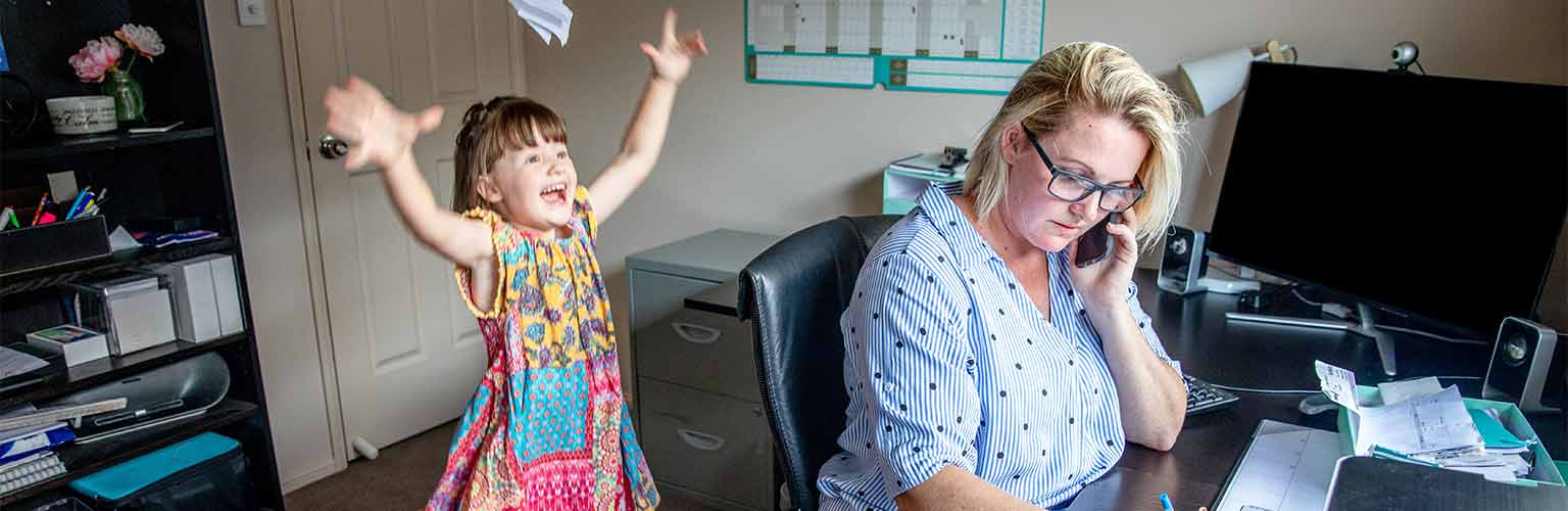 a woman attempting to work from home being distracted by her child