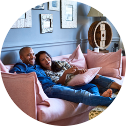 a couple enjoying watching tv on the sofa