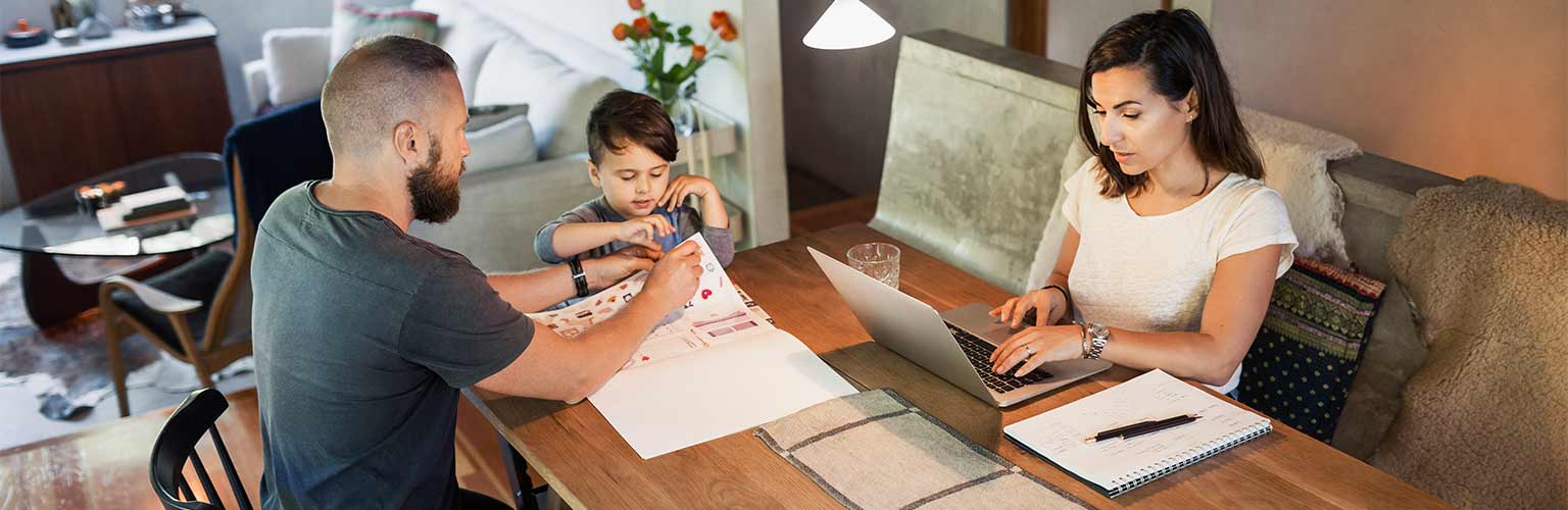 A woman working from home and a man homeschooling his child
