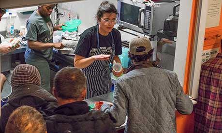 Female serving drinks in homeless shelter