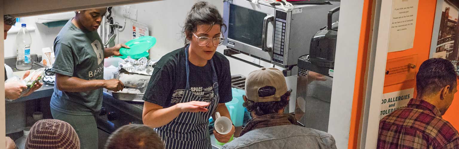 Female serving drinks in homeless shelter