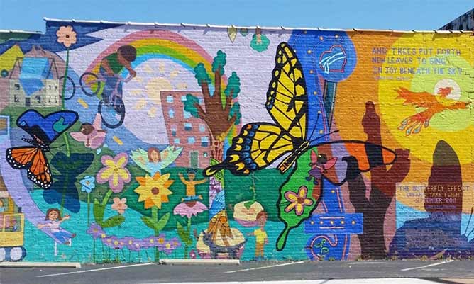A memorial on a wall with butterflies and rainbows