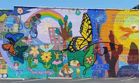 A memorial on a wall with butterflies and rainbows