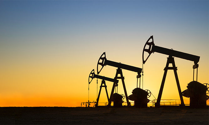 Silhouette of oil wells in desert at sunset, Texas, USA