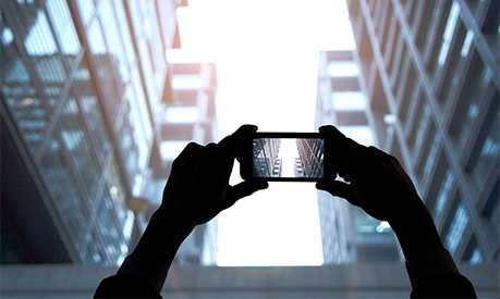 Hands photographing skyscraper buildings