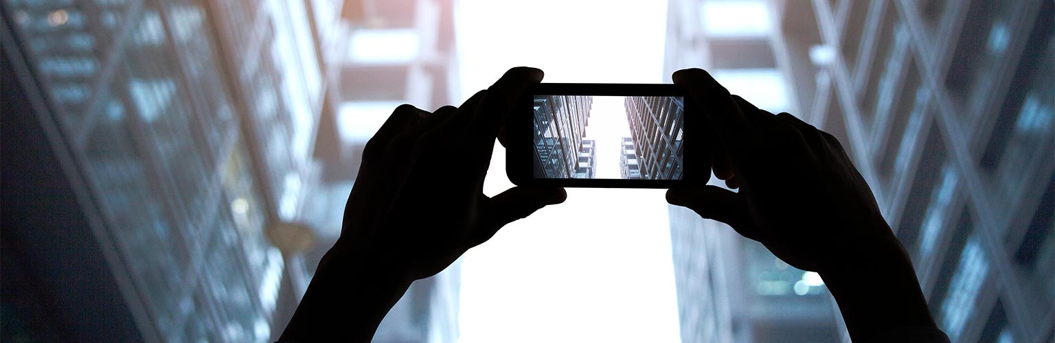 Hands photographing skyscraper buildings