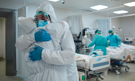 healthcare workers providing support to each other in PPE