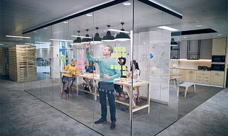 A group of people working in a start-up firm brainstorming in their office