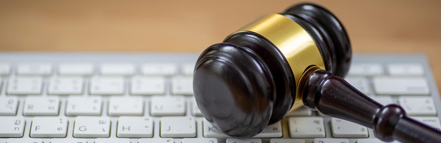 wooden gavel on computer keyboard