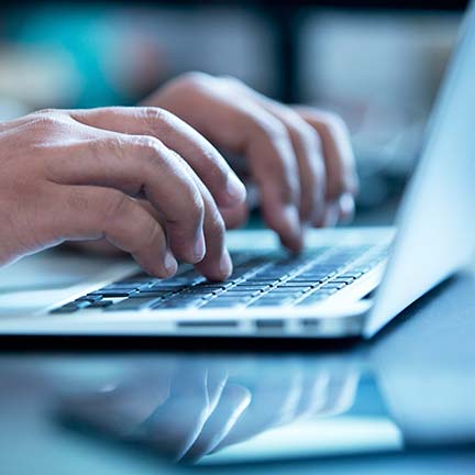 A person typing on a laptop