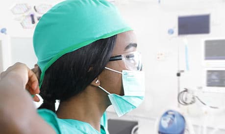 Medical professional putting on protective face mask