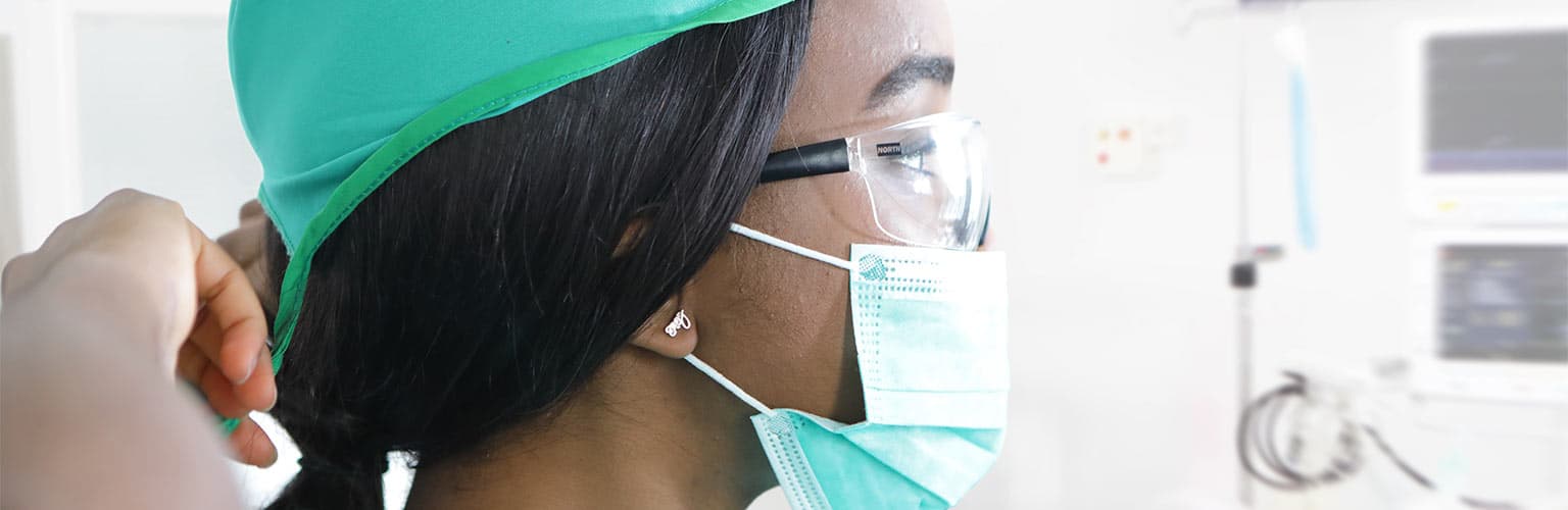 Medical professional putting on protective face mask