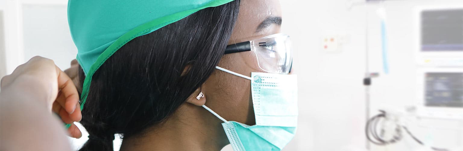 Medical professional putting on protective face mask