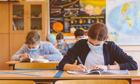 schoolchildren in class with facemasks on