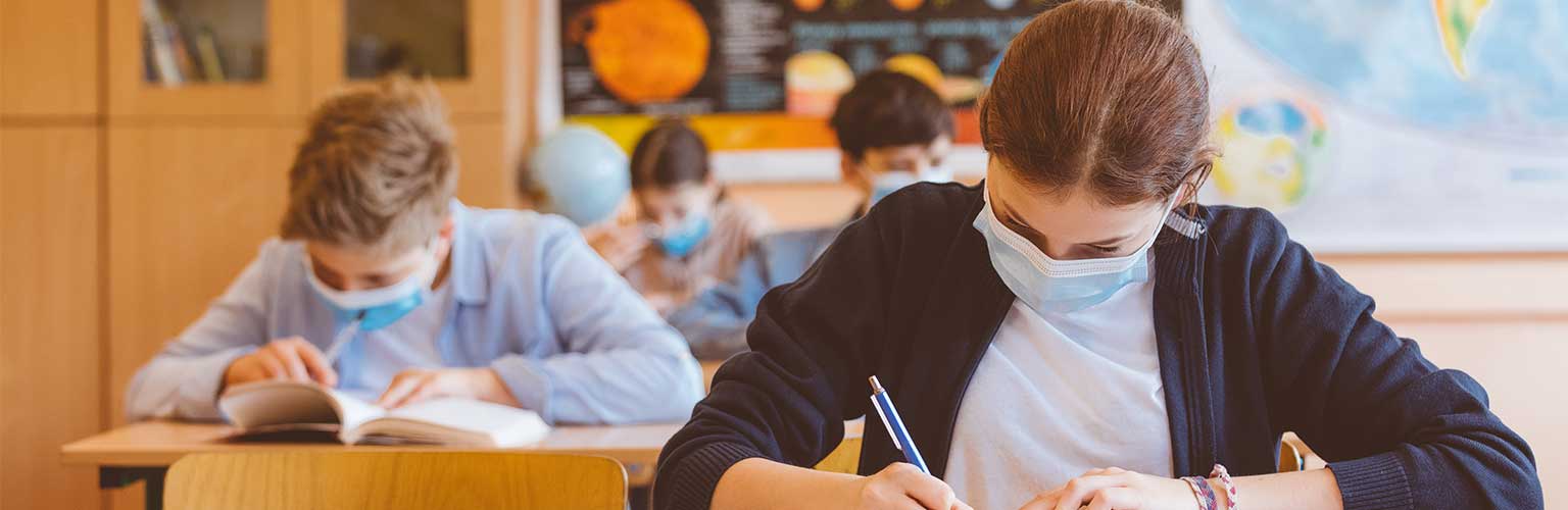 schoolchildren in class with facemasks on