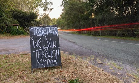 A sign on a country road which says 'together we will get through this'