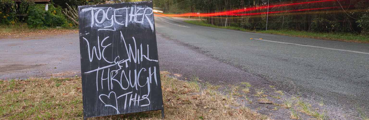 A sign on a country road which says 'together we will get through this'