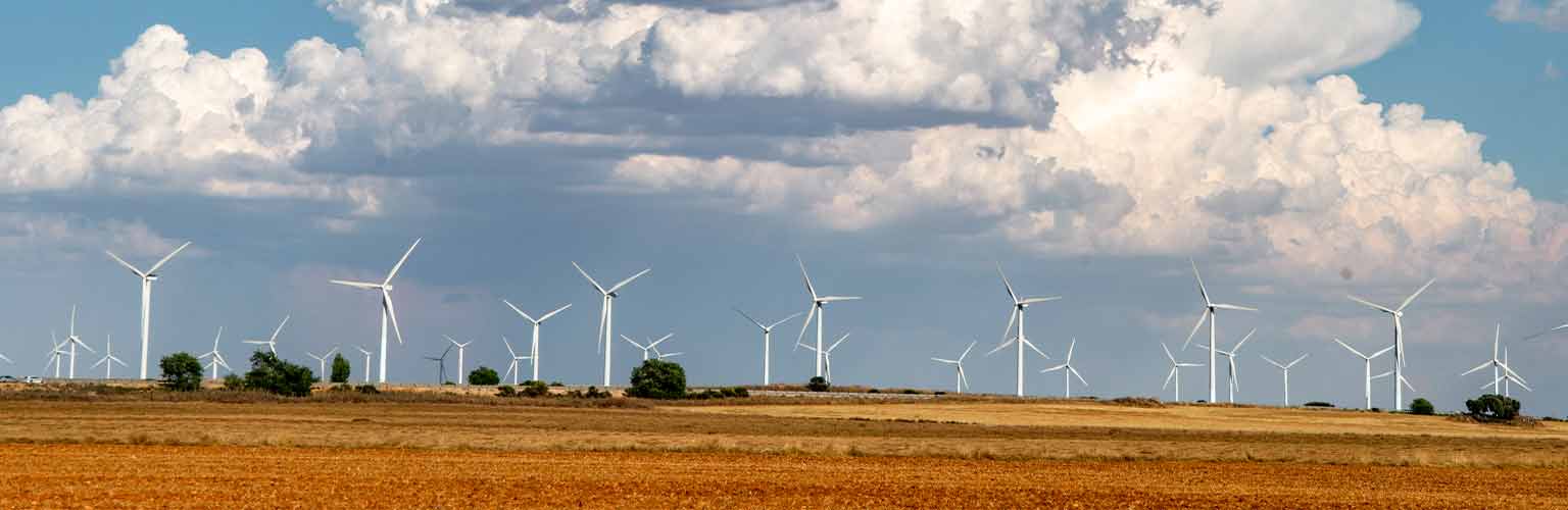 A large windfarm with a huge cloud forming above them