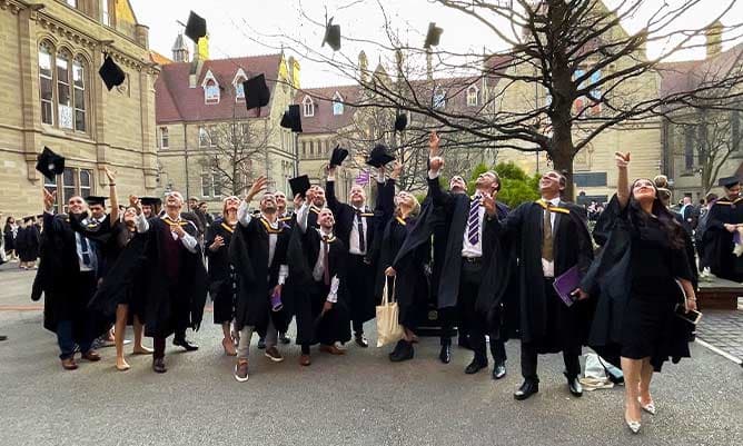 AMBS students celebrating their graduation in the Old Quadrangle at the University of Manchester