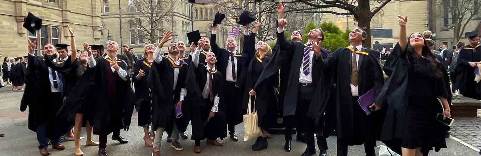 AMBS students celebrating their graduation in the Old Quadrangle at the University of Manchester