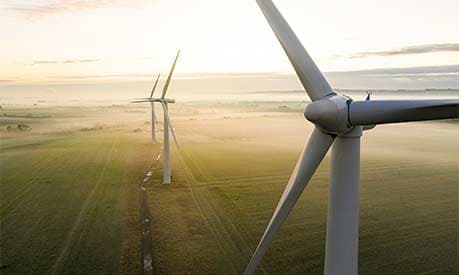 Three wind turbines at sunset