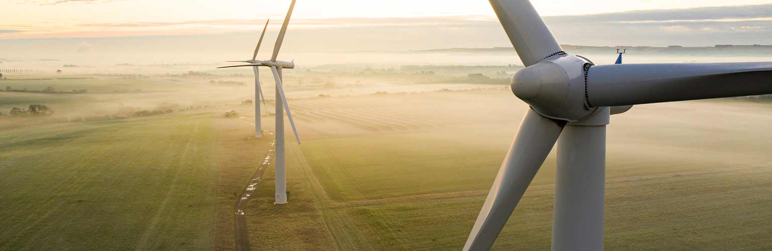 Three wind turbines at sunset