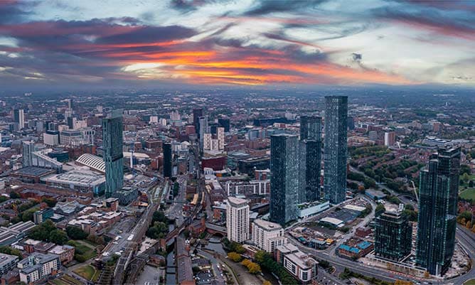 A cityscape of Manchester in the sunset