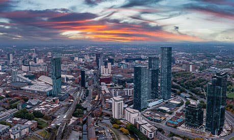 A cityscape of Manchester in the sunset