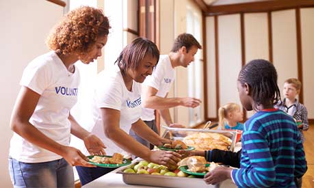 A group of volunteers at a food bank helping deliver food