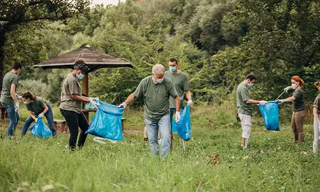 A group of volunteers picking up litter and cleaning up nature